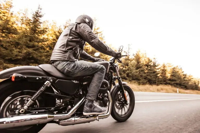 Motorcycle Insurance Guy Riding Motorcycle Down Pine Lined Road 768x512 1 Motorcycle Insurance Coverage for your bike when hitting the open road.